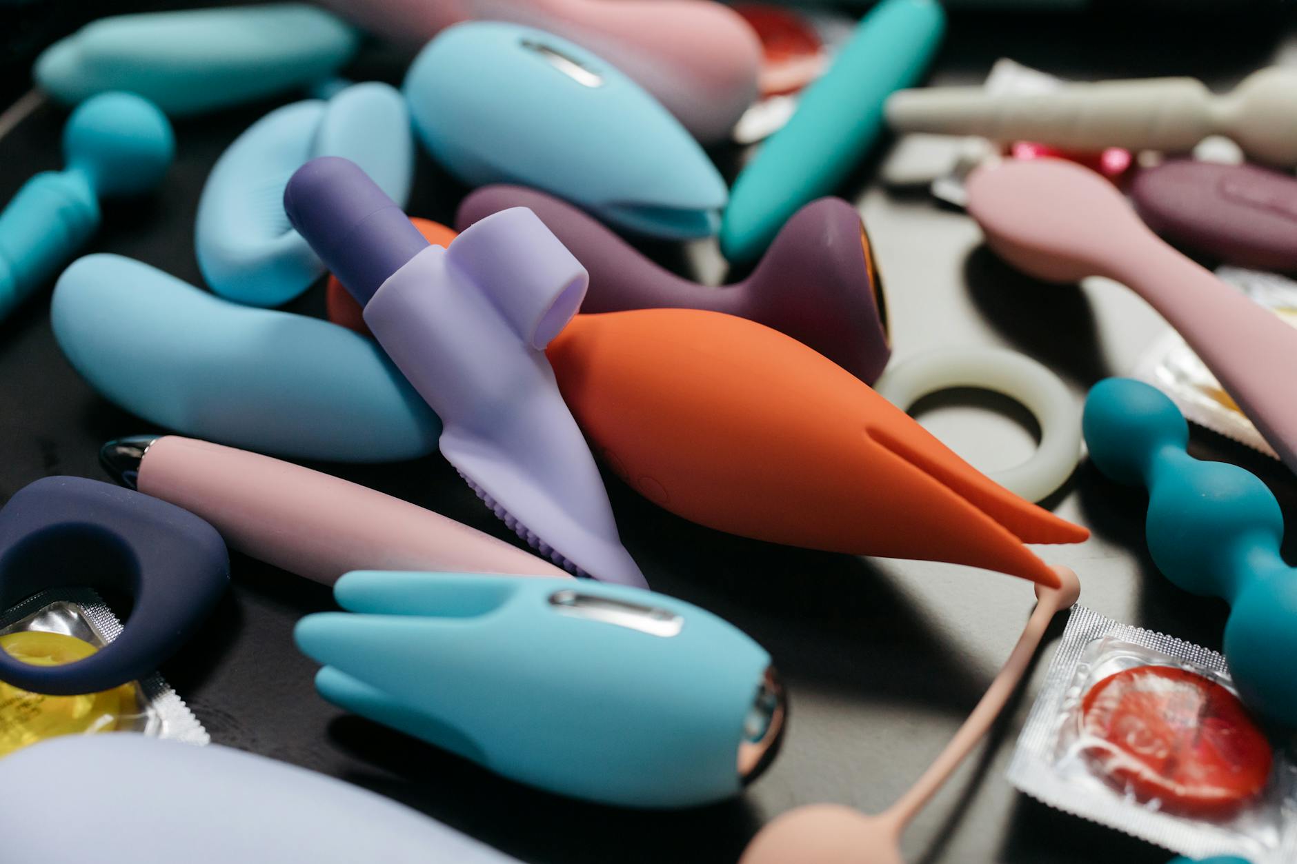 Woman holding a pink vibrator, surrounded by art books, representing intimate confidence and vulnerability.