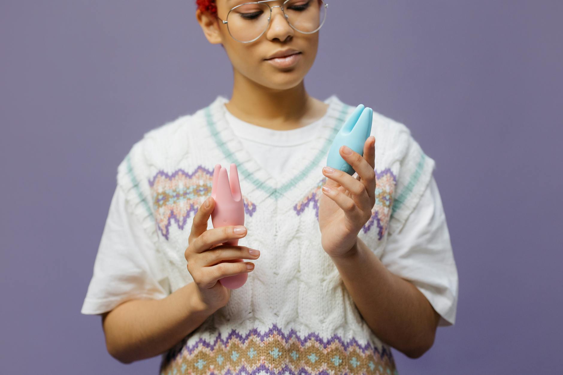 Woman holding a blue silicone vibrator with thoughtful expression, representing the moment of choosing to reconnect with pleasure