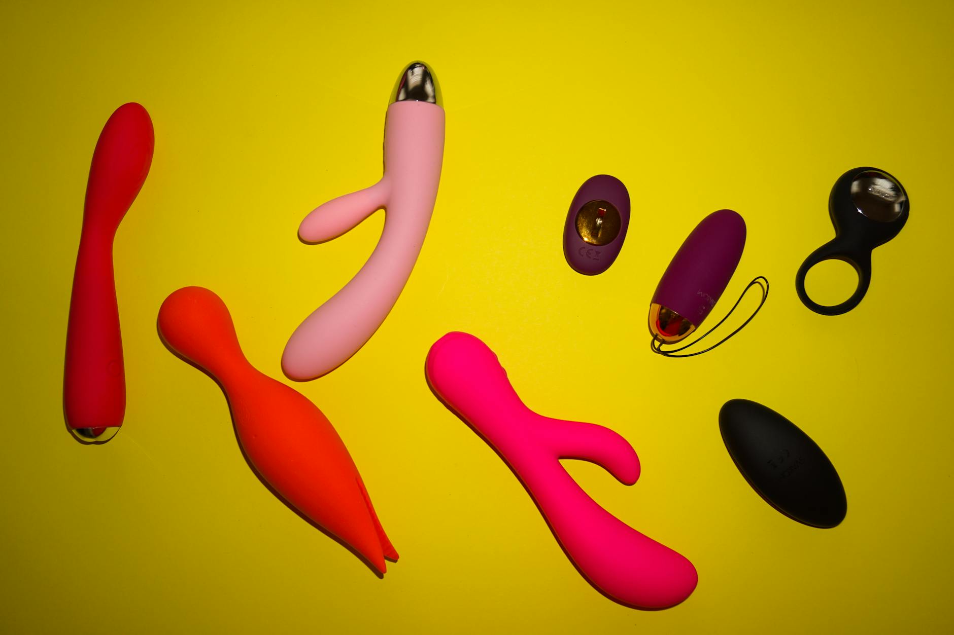 Yellow silicone vibrator with tropical fruit on yellow background