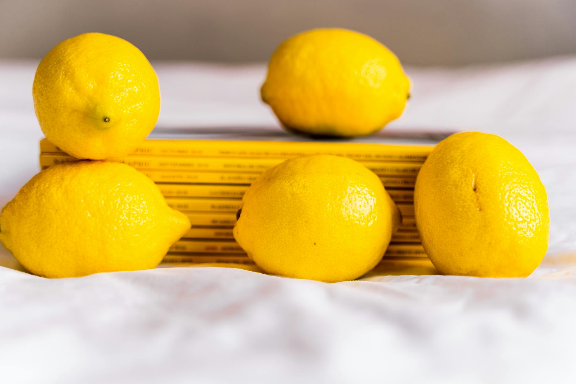 Blue vibrator surrounded by flowers and citrus slices on yellow background